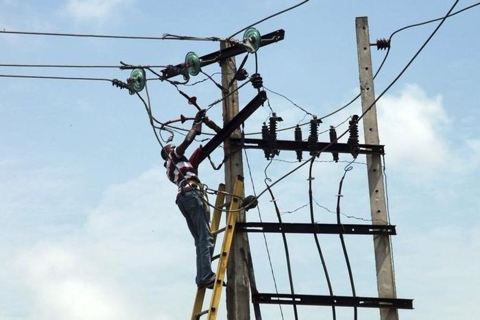 A power official works on an electric pole along a street in Nigeria's commercial capital Lagos October 3, 2012. REUTERS/Akintunde Akinleye