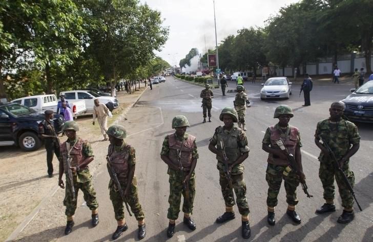 Nigerian army soldiers stand guard as they cordon off a road leading to the scene of a blast at a business district in Abuja June 25, 2014. REUTERS/Afolabi Sotunde