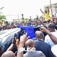 Bola Tinubu (in blue) surrounded by a crowd of supporters at his polling unit in Lagos