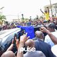 Bola Tinubu (in blue) surrounded by a crowd of supporters at his polling unit in Lagos