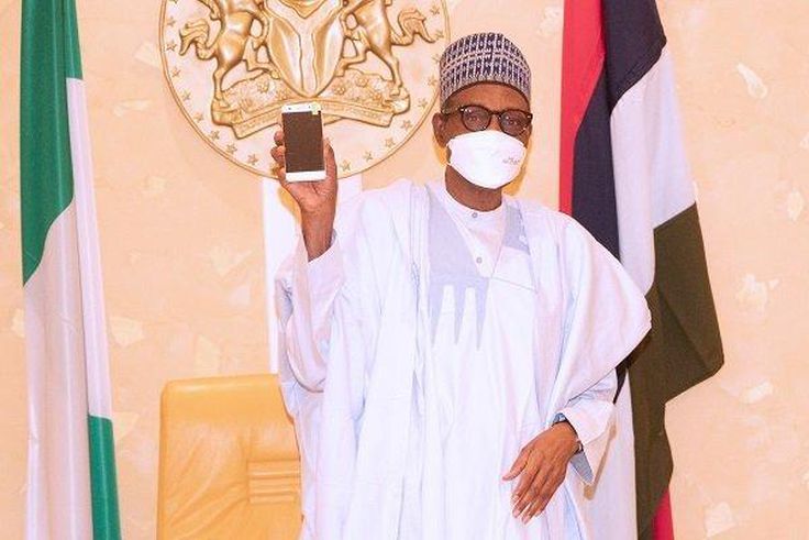 President Muhammadu Buhari receives first made in Nigeria cell phone. [The Nation]