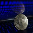 Representation of Bitcoin is seen with binary code displayed on a laptop screenNurPhoto/Getty Images