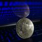 Representation of Bitcoin is seen with binary code displayed on a laptop screenNurPhoto/Getty Images