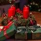Unlighted red advent candles on a table beside green gift boxes [Credit: Alex Fu]