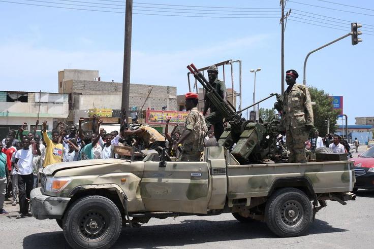Sudanese greet army soldiers, loyal to army chief Abdel Fattah al-Burhan, in the Red Sea city of Port Sudan on April 16, 2023.AFP via Getty Images