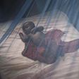 A baby under a mosquito net [Guardian]