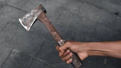 A black hand holding an axe [iStock]