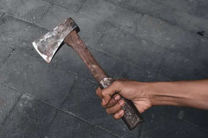 A black hand holding an axe [iStock]