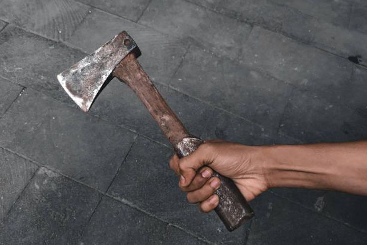 A black hand holding an axe [iStock]