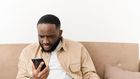 Black man angry at phone (image used for illustration) [Freepik]