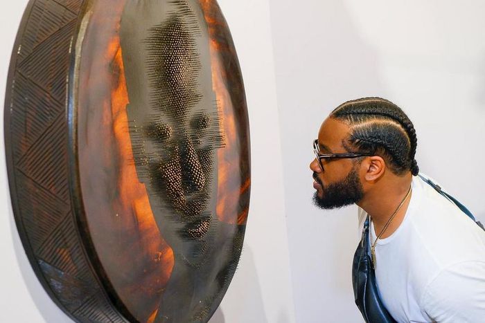 Observing an artwork at artx [Instagram/artxlagos]