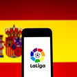 September 16, 2021, Barcelona, Catalonia, Spain: In this photo illustration a LaLiga logo seen displayed on a smartphone with a Spanish flag in the background. Barcelona Spain -