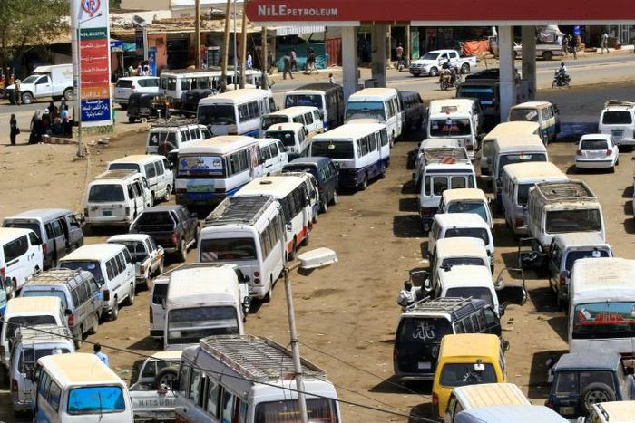 Motorists queue to fill up with petrol in Sudan where the economy is still reeling a year since the ouster of former autocratic leader Omar al-Bashir