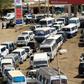 Motorists queue to fill up with petrol in Sudan where the economy is still reeling a year since the ouster of former autocratic leader Omar al-Bashir