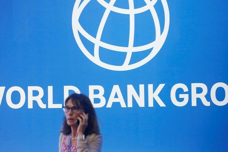 FILE PHOTO: A participant stands near a logo of World Bank at the International Monetary Fund - World Bank Annual Meeting 2018 in Nusa DuaReuters