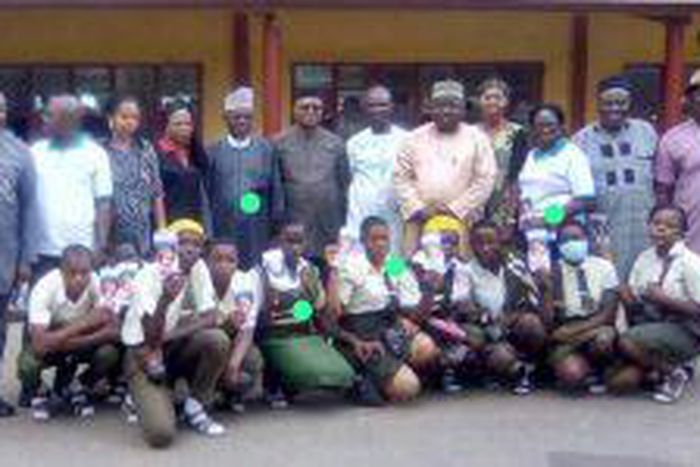 Dr Mathew Ashikeni, Director, Special duties, FCT Health and Human Services Secretariat and  Mrs Eze pose for a picture with students of Government Secondary School, Life camp, Gwarimpa Abuja where the event held. [NAN]