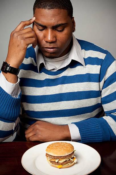 Man looking at a sandwich on a table