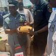 The Controller, Seme Area Command of Nigeria Customs Service, Comptroller Dera Nandi, handing over 553 parcels of cannabis sativa seized by his men to Mr Abubakar Wada, the Commander, National Drugs Law Enforcement Agency (NDLEA) on Wednesday in Semé.