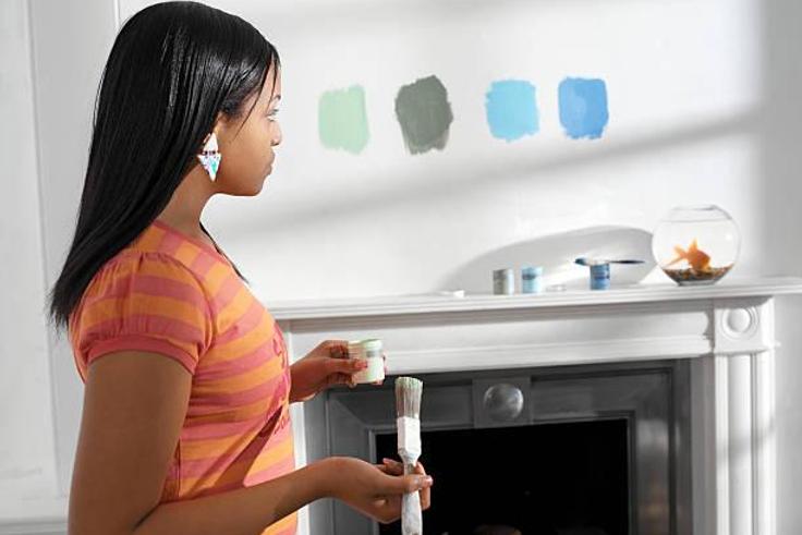 Young woman holding paint and brush