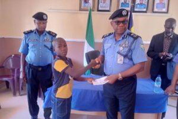 L-R: L-R: One of the deceased police officers’ children receiving a cheque from Kebbi Police Commissioner, CP Chris Aimionowane, in Birnin Kebbi on Thursday [NAN]