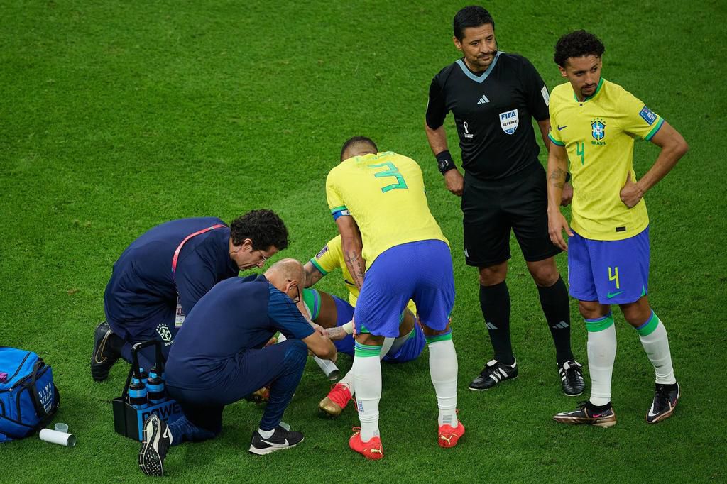 Brazil's medical team attend to Neymar against Serbia.