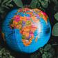 Globe in green leaves with map of Africa in view [Photo: Nothing Ahead]