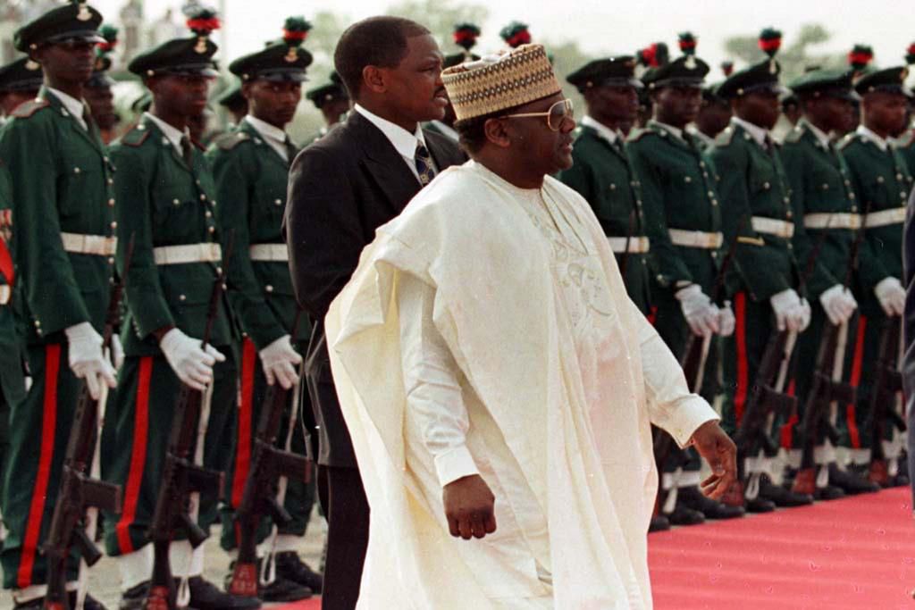 Former Nigerian President General Sani Abacha walks past a line of military troops March 23 during the departure ceremony for Pope John Paul II who was ending a three day visit to the country. NIGERIA POPE (Reuters)