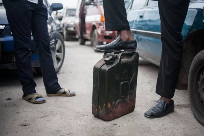 A man waits with his jerrican to buy fuel in Lagos (image used for illustration) [Stefan Heunis/AFP]