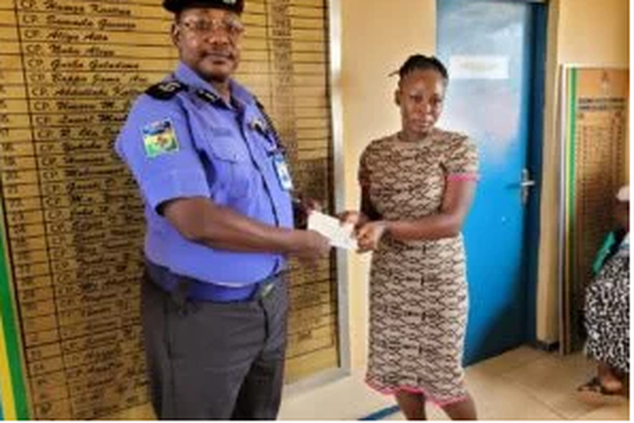 The Commissioner of Police, Kaduna State Command, Mr Musa Garba presenting cheque to a deceased police officer’s  family member, in Kaduna (Credit: NAN)