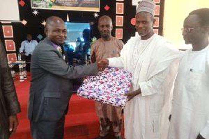 Prof. Isah Mshelgaru, Leader of a Muslim group who celebrate Christmas with Christians at EYN Church, Samaru Zaria, presenting gift to Rev. Tijjani Chindo, during the Christmas service at Zaria on Sunday.