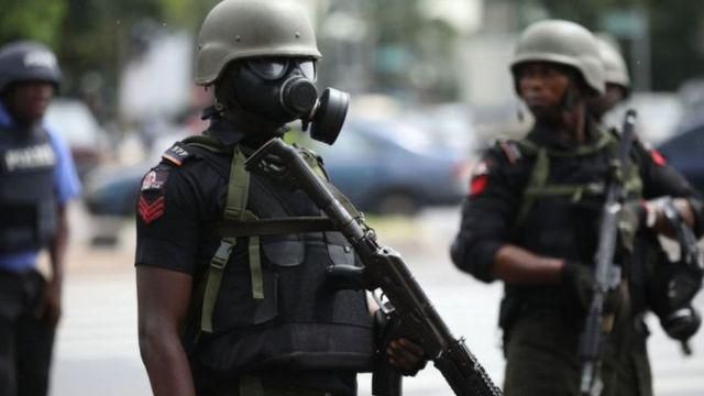 A Nigerian police officer wearing a gas mask