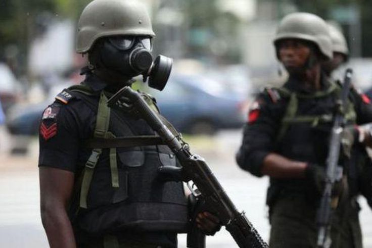 A Nigerian police officer wearing a gas mask