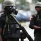 A Nigerian police officer wearing a gas mask