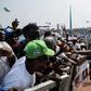 Security personnel control a crowd of supporters of Nigeria's ruling All Progressive Congress (APC) party at a stadium campaign rally in Lagos