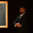 Nigerian author Ben Okri poses with a work of art by Nigerian painter and sculptor Ben Enwonwu entitled 'Tutu', the "African Mona Lisa" sold at auction in London for £1.2 million (1.4 million euros, $1.7 million), setting a record for the artist
