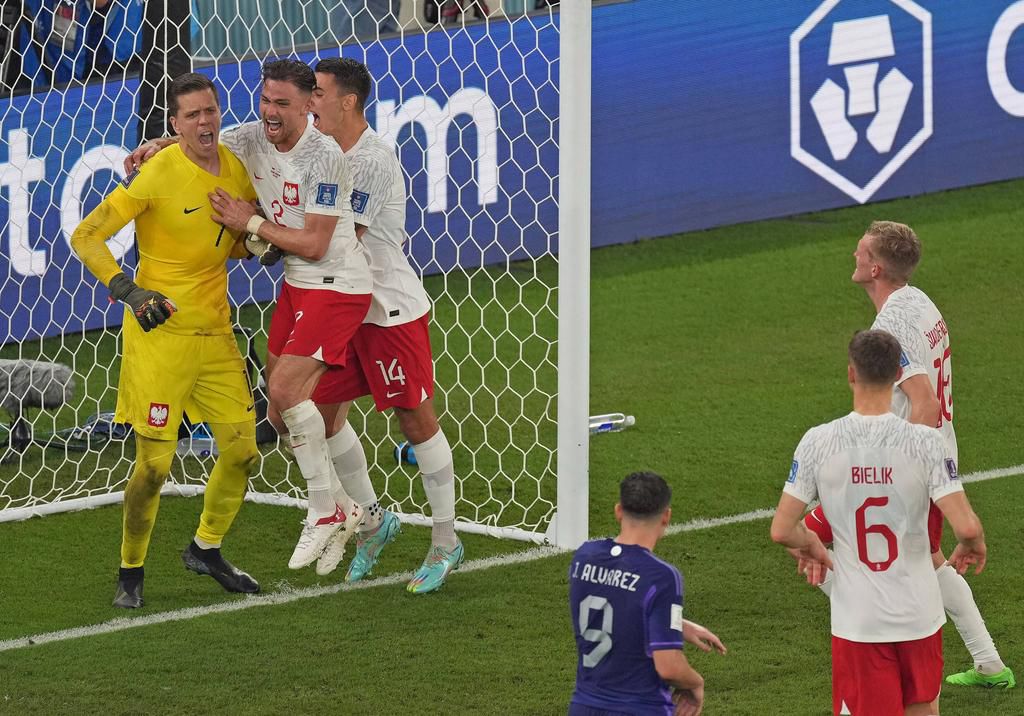 Wojciech Szczesny(L), goalkeeper of Poland, celebrates with teammates after blocking a penalty kick by Lionel Messi of Argentina during the Group C match between Poland and Argentina at the 2022 FIFA World Cup on November 30, 2022.