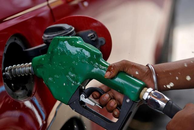 FILE PHOTO: A worker holds a nozzle to pump petrol into a vehicle at a fuel station in Mumbai, India, May 21, 2018. REUTERS/Francis Mascarenhas/File Photo