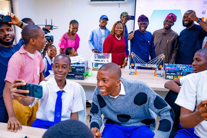 Behind: Lagos State Governor, Mr Babajide Sanwo-Olu (third right); Senator Adetokunbo Abiru (second right); his wife/Co-founder of the SAIL (Senator Abiru Innovation Lab), Mrs Feyisola Abiru (third left), taking a selfie with some students during the o...