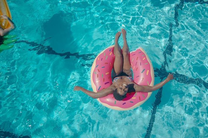 Woman on a pink swim ring [Photo: Kindel Media]