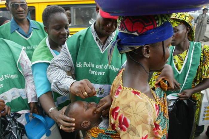 Health officers administering vaccine to infants during immunisation exercise in Nigeria