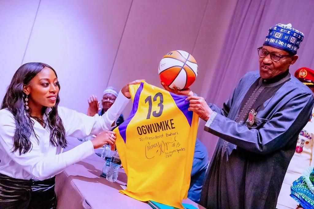 President Buhari receives a jersey from WNBA star Chiney Ogwumike.