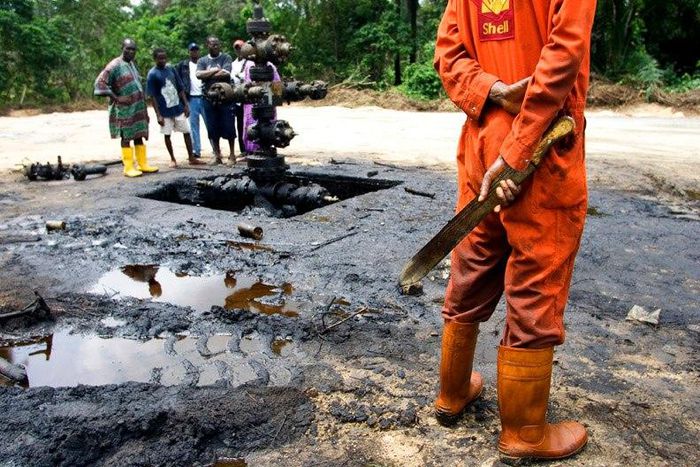 Workers subcontracted by Shell Oil Company clean up an oil spill from an abandoned Shell Petroleum Development Company well in Oloibiri, Niger Delta.