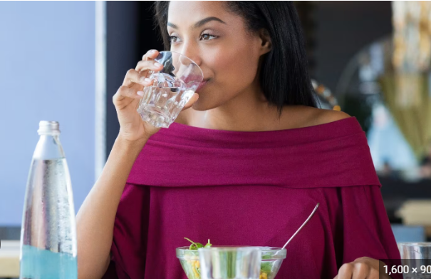 Lady drinking while eating