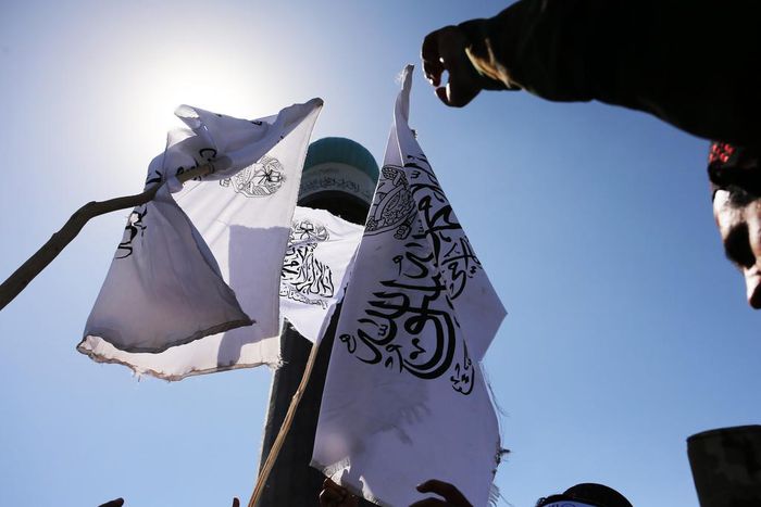 Taliban fighters stand next to Taliban flag on August 31, 2022.Bilal Guler/Anadolu Agency via Getty Images