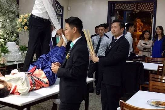 Korean wedding tradition where the groom's feet is tied and flogged