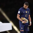 A dejected Mbappe walks past the World Cup title.