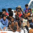 Migrants from Tunisia and Libya arrive onboard of an Italian Coast Guard boat on the Italian island of Lampedusa on August 1