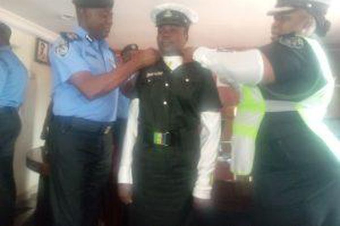 CP Idowu Owohunwa decorating promoted Insp. Ajara Isede of the Lagos Police Traffick Division on Thursday in Lagos. [(NAN]