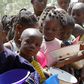 A stream of children wait in line during a food distribution at a feeding centre. [Getty Images]