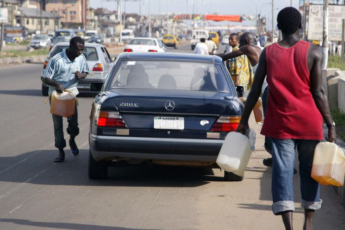Black market fuel vendors tries to sell fuel to a motorist on Lagos-Ikorodu highway 17 June 2007. [Getty Images]